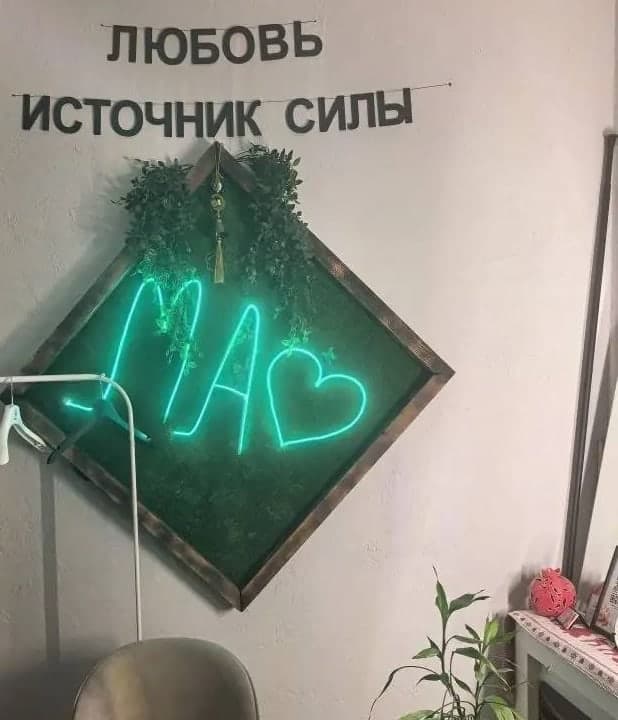 Неоновая надпись «Ма» в ромбе со мхом и слова «Любовь — источник силы» на стене